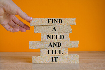 Find a need and fill it symbol. Concept words Find a need and fill it on brick blocks. Beautiful orange background. Businessman hand. Business and find a need and fill it concept. Copy space.