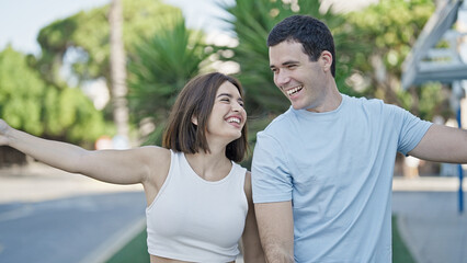 Beautiful couple smiling confident standing together dancing at park