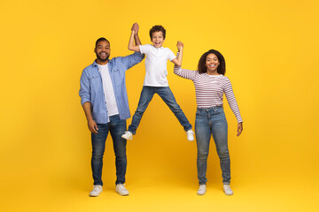 Cheerful Young Black Family Of Three Having Fun Together Over Yellow Background
