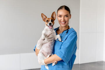 Cheerful vet holding a smiling Jack Russell