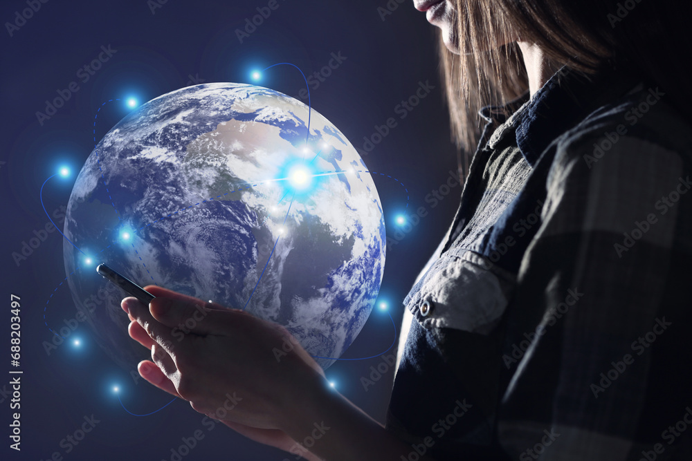 Poster global network. woman using smartphone on dark background, closeup. digital image of earth with conn