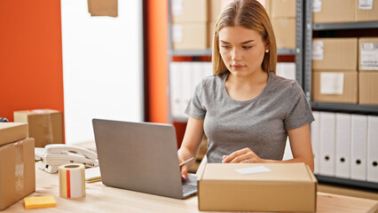 Young blonde woman ecommerce business worker using laptop at office