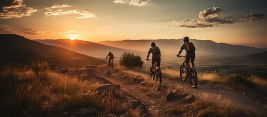 Muurstickers Mountain bikers riding on a mountain trail during sunset © Photo And Art Panda