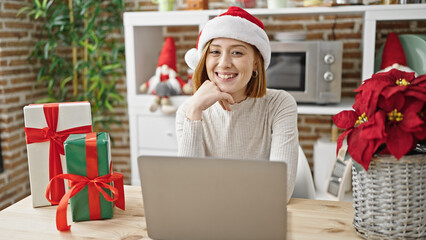 Young blonde woman using laptop celebrating christmas at dinning room