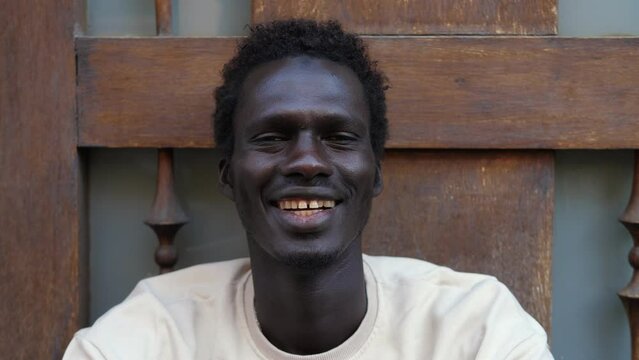 witty african boy feigns frown and then laughs at the camera