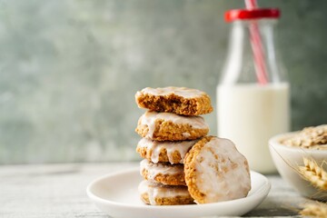 Homemade iced oatmeal cookies served with milk, selective focus