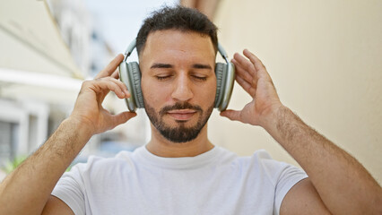 Young arab man listening to music at street