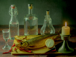 Still life in antique style with fish and alcohol on a wooden table. - 688211849