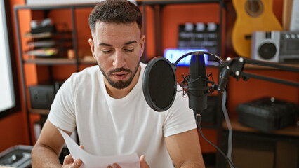 Young arab man musical reporter speaking on radio show at music studio