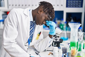 African american man scientist stressed writing report at laboratory