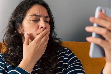 Middle-Aged Woman Using Smartphone for Video Call and Expressing Worry