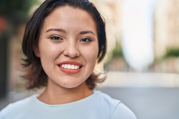 Young hispanic woman smiling confident standing at street