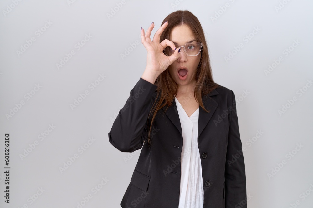 Sticker beautiful brunette woman wearing business jacket and glasses doing ok gesture shocked with surprised