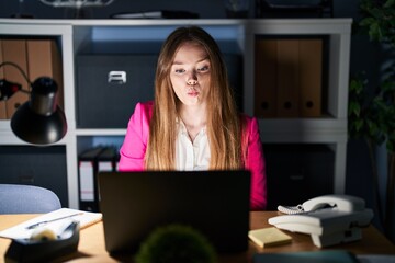 Young caucasian woman working at the office at night making fish face with lips, crazy and comical gesture. funny expression.