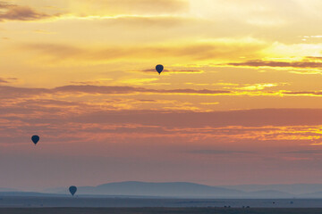 A beautiful landscape photo shot in Masai Mara Kenya, the photo also shows vast dramatic sky and balloon safari in the morning.