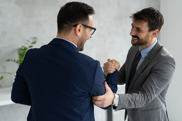 Business people handshaking and smiling at office