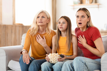 Shocked family watching TV together at home