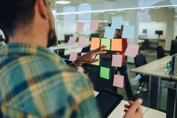 Close up of a creative team writing ideas and concepts on sticky notes.