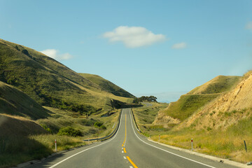blue skies ahead, a road in a green mountainous valley, NZ