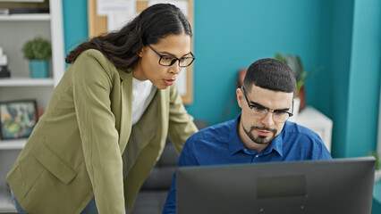 Dynamic duo at work, two professional workers, man and woman, conjuring success at their desk...