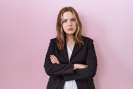 Young caucasian business woman wearing black jacket skeptic and nervous, disapproving expression on face with crossed arms. negative person.