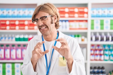 Caucasian man with mustache working at pharmacy drugstore disgusted expression, displeased and...