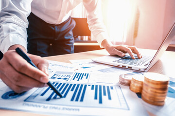 Businessman accountant or financial expert analyze business report graph and finance chart at...