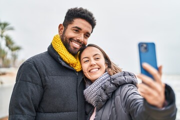 Man and woman couple smiling confident make selfie by smartphone at seaside