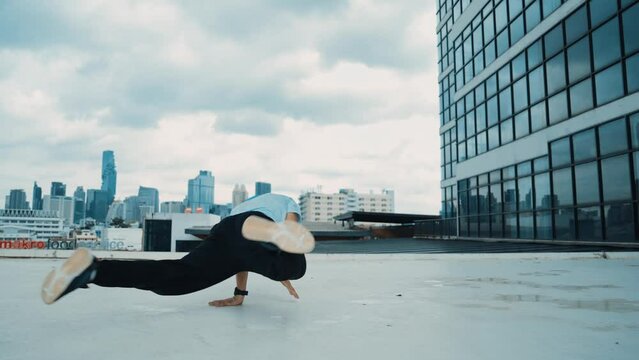 Stylish caucasian dancing man performing break dance at skyscraper. Portrait image of young happy man practicing dance performance choreographer in modern urban city. Outdoor sport 2024.. hiphop.