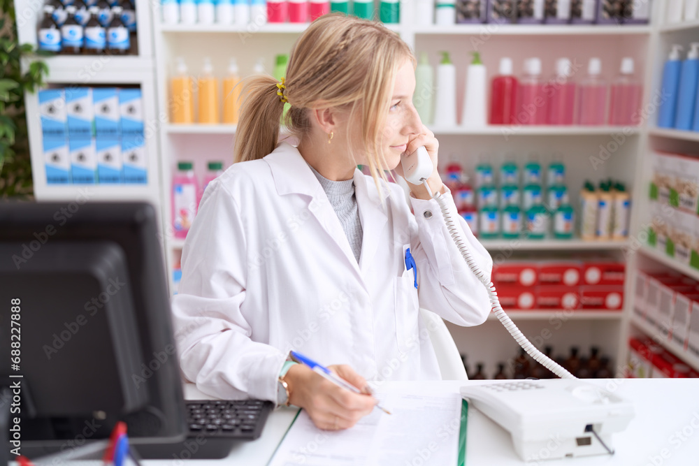 Poster Young caucasian woman working at pharmacy drugstore speaking on the telephone looking to side, relax profile pose with natural face and confident smile.