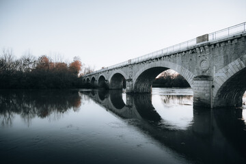 Naklejka premium Bridge over the water at sunset in Saubusse