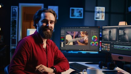 Portrait of happy videographer using professional software to create visual effects for video projects. Smiling expert using post production techniques to edit raw clips footage, zoom in shot - obrazy, fototapety, plakaty