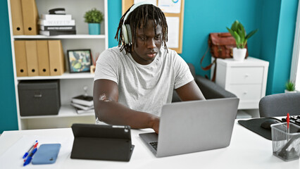 African american man business worker using touchpad and laptop working at the office