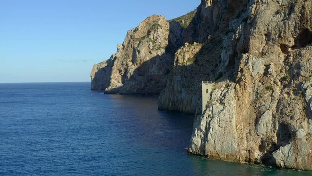 Aerial drone view of Porto Flavia mines entrance on the rocks in Sardinia, Italy