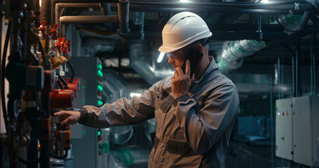 Male heavy industry worker wearing safety uniform, protective glasses and hard hat inspects...