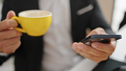 Young man business worker using smartphone drinking coffee at office