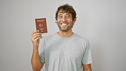 Turk youngster beaming with joy, holding his passport to turkey, isolated on a white background