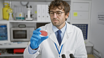 Young man scientist looking at sample at laboratory
