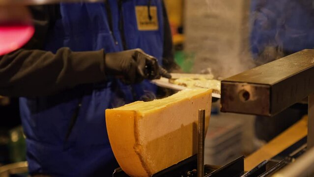 Melting cheese wheel used to make traditional Cheese Raclette at a Christmas market stall in Vienna, Austria