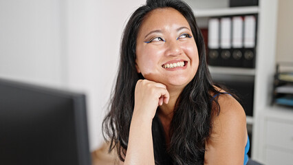 Young chinese woman business worker using computer looking to the side at the office