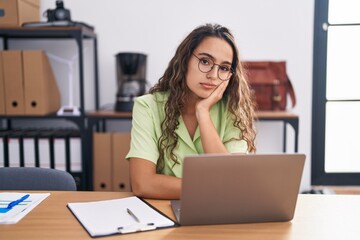 Young hispanic woman working at the office wearing glasses thinking looking tired and bored with depression problems with crossed arms. - obrazy, fototapety, plakaty