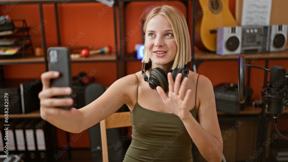 Canvas Prints Young blonde woman musician having video call smiling at podcast studio