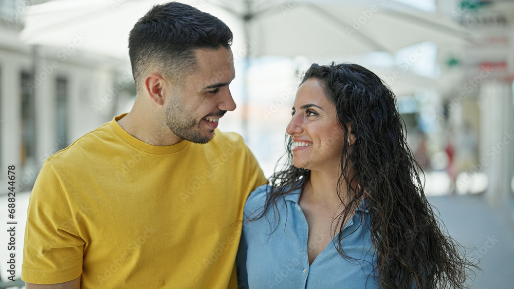 Poster Man and woman couple smiling confident looking each other at street