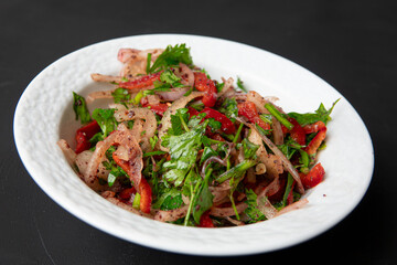 Salad with sliced lemon, onion, parsley, red pepper and tomatoes in porcelain bowl on dark background. Appetizer for Turkish pizza, pita pizza Lahmacun