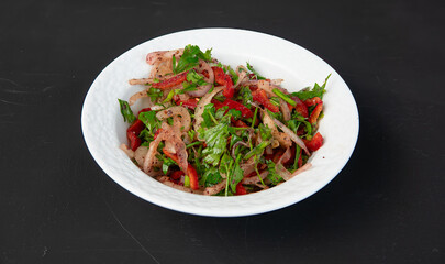 Salad with onion, parsley, red pepper 
sumach and tomatoes in porcelain bowl on dark background....