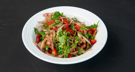 Salad with onion, parsley, red pepper 
sumach and tomatoes in porcelain bowl on dark background. Appetizer for Turkish pizza, pita pizza Lahmacun