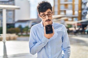 Young caucasian man talking on the smartphone with serious expression at street