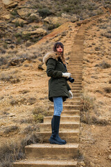 Brown-haired woman walks in arid desert.