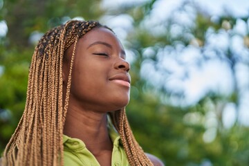 African american woman breathing with closed eyes at park