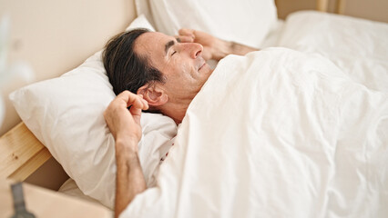 Fototapeta na wymiar Middle age man lying on bed sleeping at bedroom